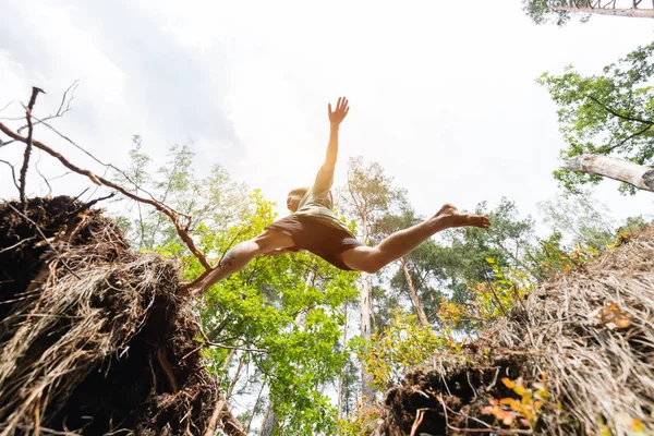 Young man making a jump in the forest. — Stock Photo, Image