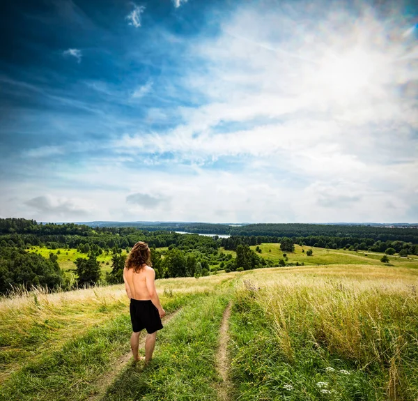 Junger Mann steht auf einem Bergweg. — Stockfoto