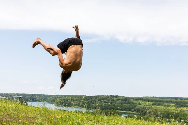 Young man jumping on a hill. — Stock Photo, Image