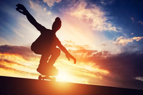 Man skateboarden bij zonsondergang. — Stockfoto