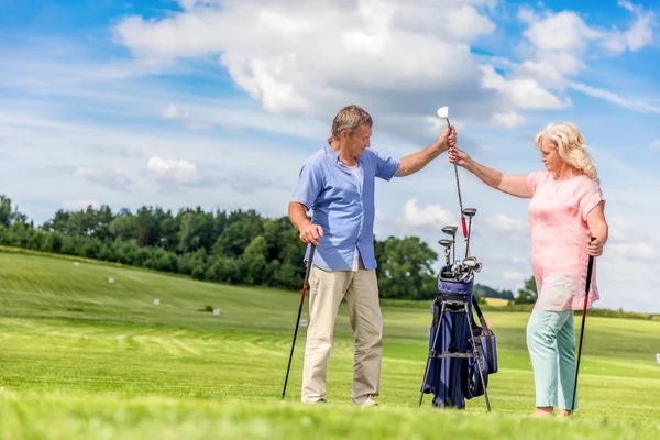 Senior paar kiezen van apparatuur voor een golfspel. — Stockfoto