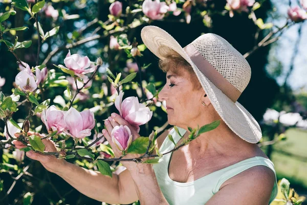 Ανώτερος Γυναίκα Μυρίζοντας Λουλούδια Ένα Δέντρο Στον Κήπο Καλοκαιρινές Δραστηριότητες — Φωτογραφία Αρχείου