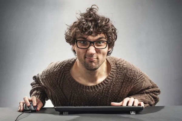 Young concentrated man playing video game on a computer. Nerd concept.