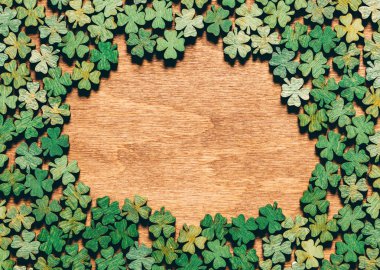 Four-leaf clovers laying on wooden floor, creating a circle. Irish culture. St. Patrick's Day. clipart