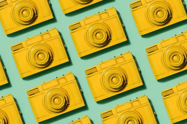 パステル調の緑の背景の行で敷設レトロな黄色のカメラ 写真コンセプト — ストック写真