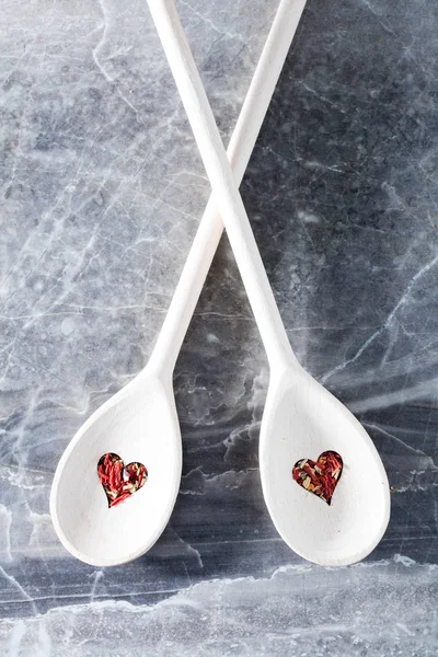 Δύο Ξύλινα Κουτάλια Σχήμα Καρδιάς Τρύπες Και Τσίλι Ξηρό Καρύκευμα — Φωτογραφία Αρχείου