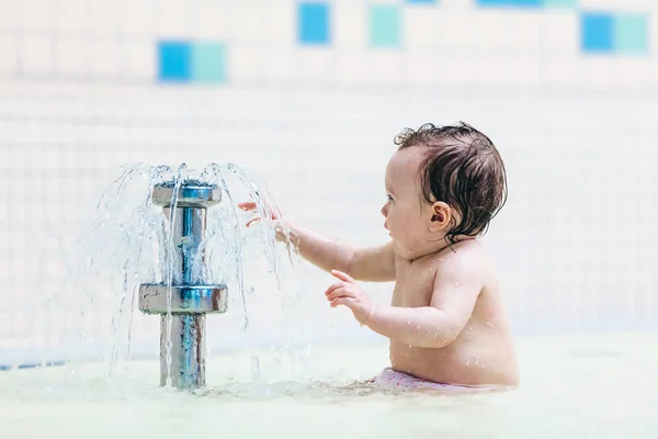 小さな噴水の前に座っている幼児 — ストック写真