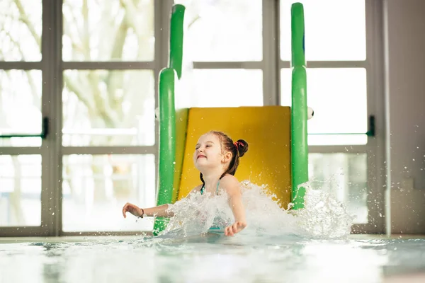 ウォーター スライドを滑り落ちると水しぶきの女の子 — ストック写真