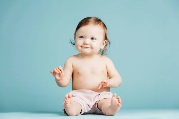 Lachende Meisje Zittend Vloer Lichte Blauwe Achtergrond — Stockfoto