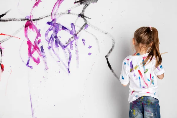 Menina Pintando Parede Branca Com Tinta Colorida — Fotografia de Stock