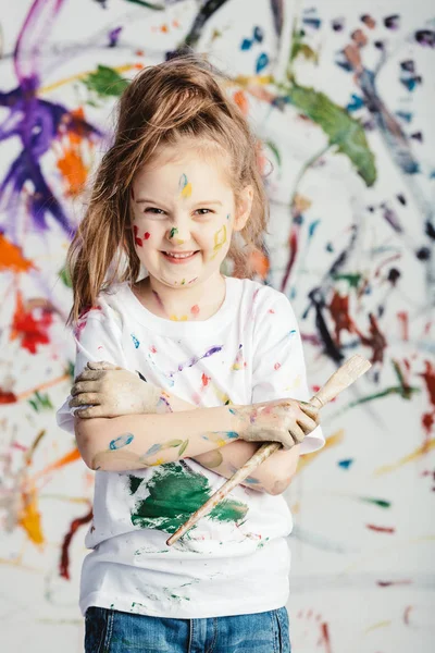 Sorrindo Menina Com Pincel Pintura Frente Fundo Bagunçado — Fotografia de Stock