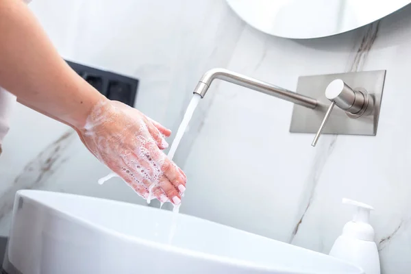 Woman washing hands with foam soap. Hygiene, preventing coronavirus and healthcare