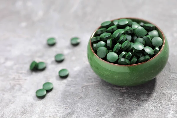 Tablety spiruliny v zelené prohlubni — Stock fotografie