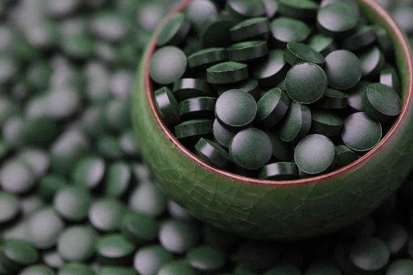 Χάπια σπιρουλίνας σε πράσινο μπολ — Φωτογραφία Αρχείου