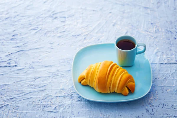 Croissant met kopje espresso op plaat — Stockfoto