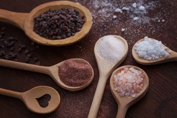 Various salt in wooden spoons — Stock fotografie
