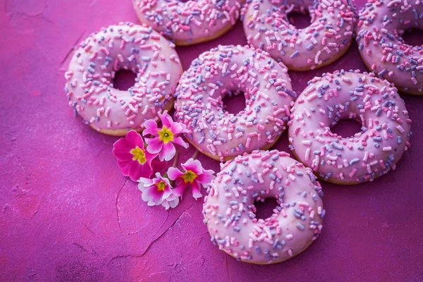 delicious pink donuts on pink background - sweet food
