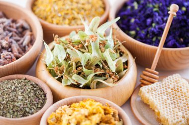 wooden bowls with herbs and tea, close up clipart