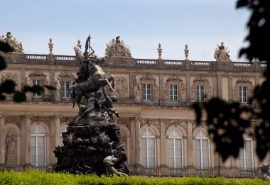 Germany, Southen Bavaria - June 28, 2012:  Herrenchiemsee royal palace of King Ludwig II of Bavaria (bavarian versailles) with decorative statue. clipart