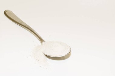 tuz ve gümüş kaşık beyaz arka plan üzerinde izole yığını.
