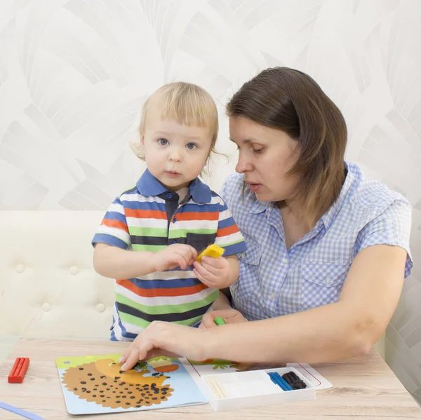 Kreş renkli kil ile oynayan genç güzel kadın ve çocuk çocuk