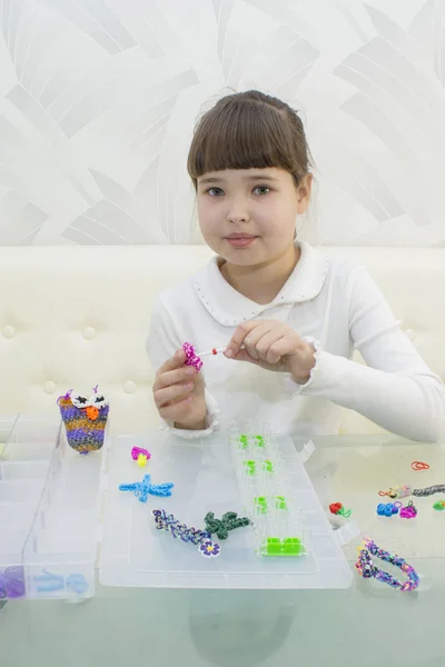 Une fille souriante avec une coiffure à la mode avec des bracelets de tissage à la main à la mode sur un fond blanc — Photo