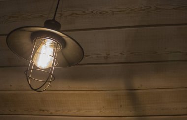 Eski moda vintage fener lamba ile yumuşak bir yanan ışık yaşlı ahşap duvar ile bir antika rustik ülke ahırda kızdırma ve ahşap zemin yıpranmış.