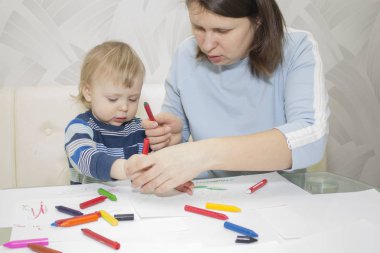 Anne ve oğlu ile birlikte kalem masada çizim.