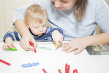 Anne ve oğlu ile birlikte kalem masada çizim.
