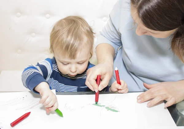 Mor och son drar tillsammans med pennor på bord — Stockfoto