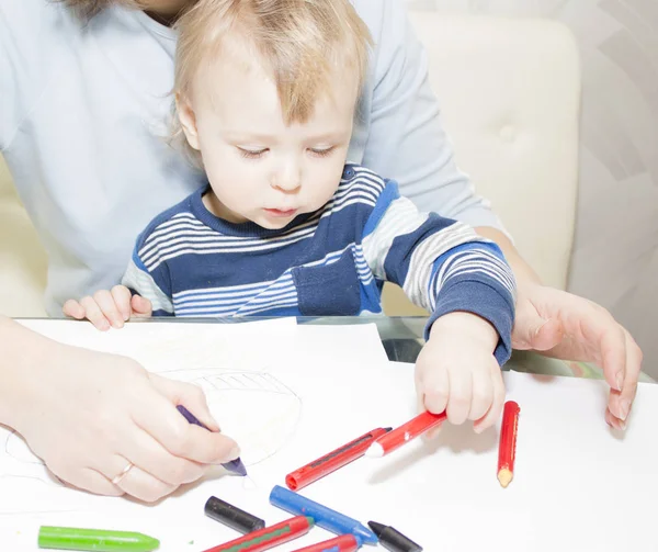 Mère et fils dessinent ensemble avec des crayons à table — Photo