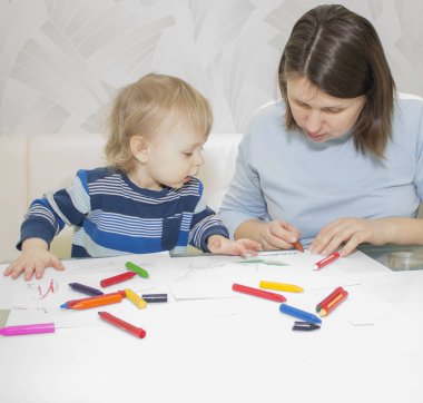 Anne ve oğlu ile birlikte kalem masada çizim