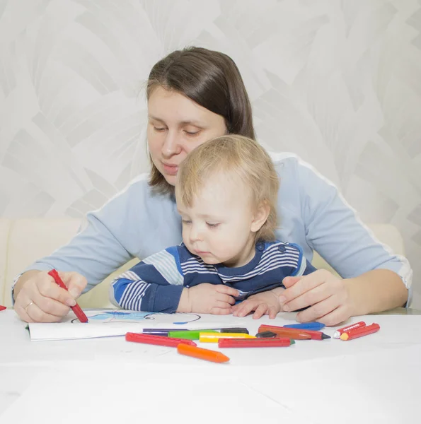 Mor och son drar tillsammans med pennor på bord — Stockfoto