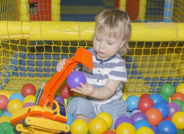 Bir çocuk oyuncaklarla oynar. Oyuncak Ekskavatör.