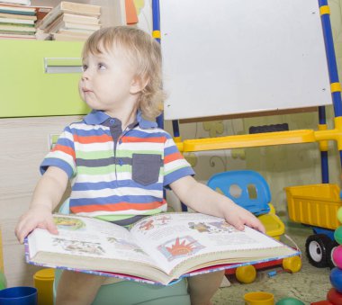 küçük çocuk lazımlık üzerinde oturan