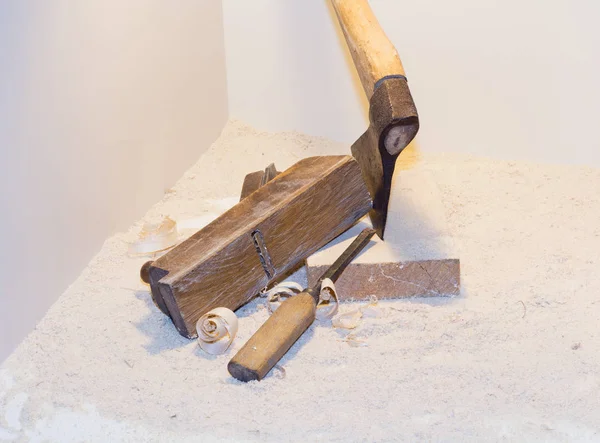 Old ax, plane, chisel and wood shavings on a light background — Stock Photo, Image
