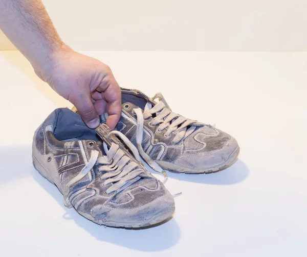 Very old running shoes with laces on a light background. — Stock Photo, Image
