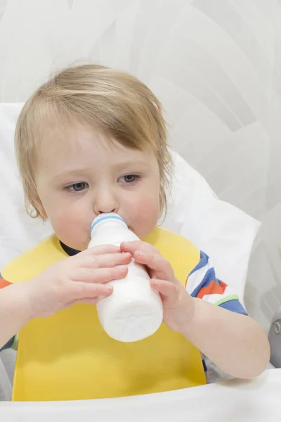 작은 아이 우유를 마시고 있다. 우유의 유리를 잡고 — 스톡 사진