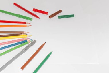 Boş kağıt ve ahşap masada renkli kalemler. Yukarıdan görüntüle