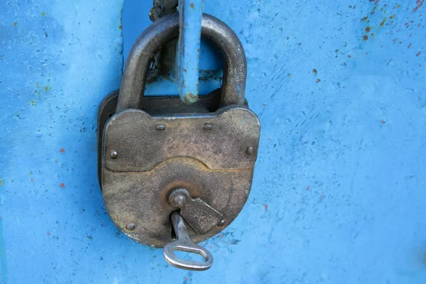 Stary zardzewiały blokada z kluczem na niebieskim tle — Zdjęcie stockowe