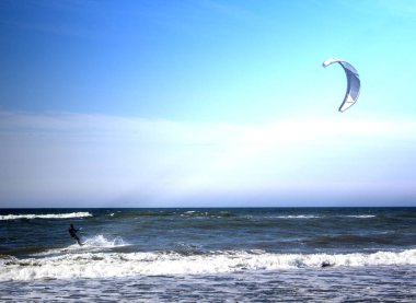 Sprey güzel bir arka plan üzerinde gün batımı sırasında atlama Kitesurfer