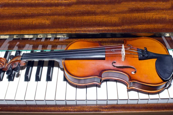 Très vieux violon couché sur le piano — Photo