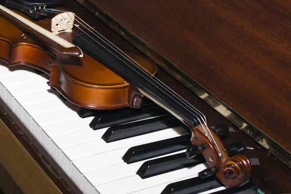 Très vieux violon couché sur le piano — Photo