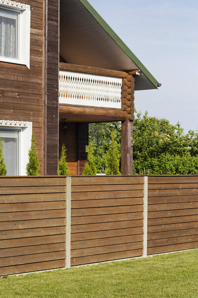 A traditional wooden house, green grass and a blue sky