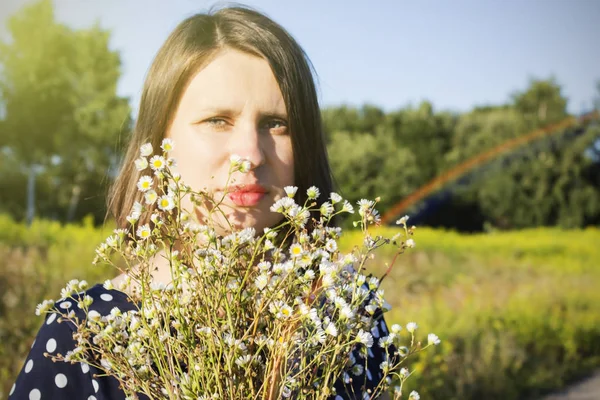 Молодая счастливая девушка с букетом на поле ромашки — стоковое фото
