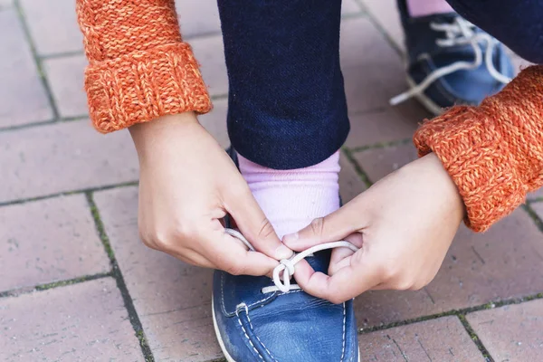 Крупним планом дівчата-підлітки руки зав'язують шнурки . — стокове фото