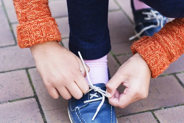 Primer plano de una adolescente manos atando cordones . —  Fotos de Stock