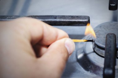 bir adam bir maç ile gaz ocağı aydınlatma