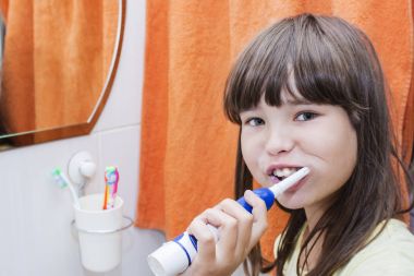 Bir banyo dişlerini fırçalama bir çocuk kız