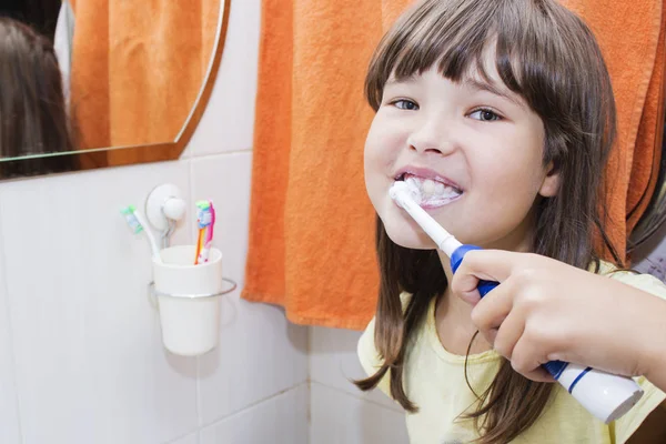 Egy gyerek lány foga fogmosás a fürdő szoba — Stock Fotó